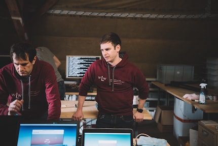 Tobias Schär nella stanza dove i vecchi notebook vengono rimessi a nuovo per una seconda vita. Nell'immagine a sinistra: David Werder, volontario.