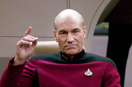 Patrick Stewart as Captain Jean-Luc Piccard with the Starfleet pin on his chest.