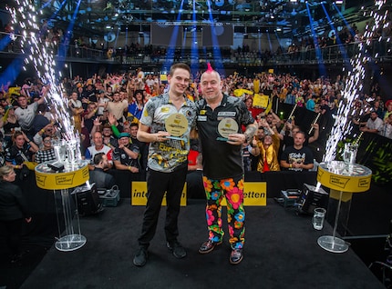 La stella cadente tedesca Ricardo Pietreczko (a sinistra) dopo la sua vittoria al Campionato Tedesco di Freccette di Hildesheim contro Peter Wright (a destra).