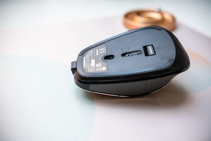 The dongle for the wireless connection adheres magnetically to the underside of the mouse.