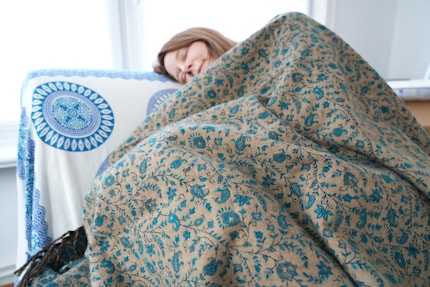 Another solid napping spot: wrapped in a blanket on the armchair.