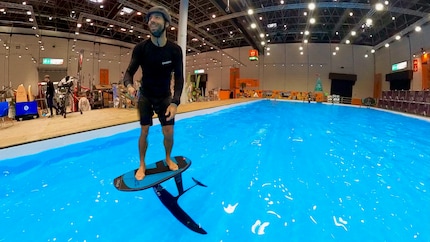 Michi Näf, rider del team Ensis, dimostra nella piscina del salone nautico come una tavola si solleva dall’acqua con un hydrofoil e la forza dei muscoli.