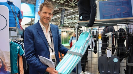 Il co-direttore di Fourth Element Jim Standing con le pinne realizzate in plastica riciclata al «Boot» di Düsseldorf.