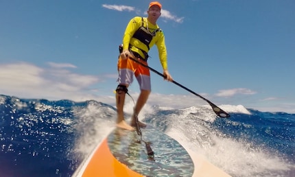 Pagaiare sottovento sul SUP tra le isole Hawaii.