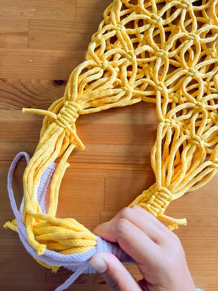 Avvolgo strettamente la corda viola intorno alle corde gialle. Mi ci vogliono diversi tentativi prima di ottenere un risultato soddisfacente.