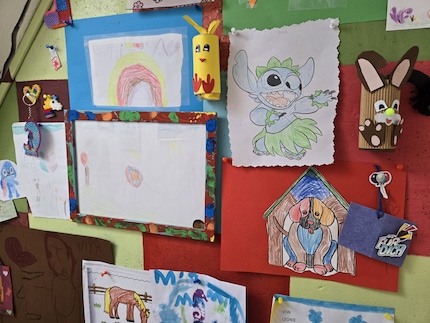 Una stanza piccola e non illuminata con le opere d'arte di mia nipote, eppure i colori sono radiosi.