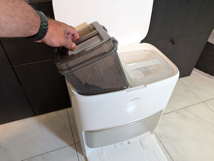 La stazione base con il serbatoio di colore scuro dell'acqua sporca e il serbatoio di colore chiaro per l'acqua pulita.