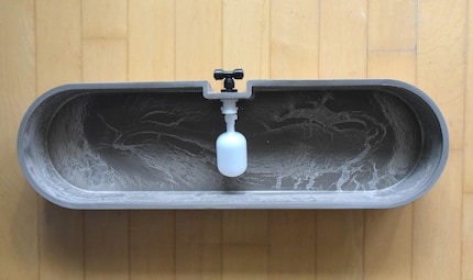 The reservoir feeds enough water via the T-piece (black) until the float valve (white) has reached the maximum level.