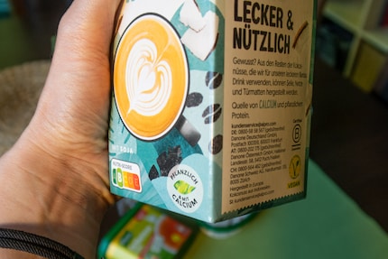 Alpro pubblicizza «Barista Cocco» sulla parte anteriore con la dicitura «Vegetale e con calcio aggiunto». L'etichetta gialla V-Label è riportata sul lato della confezione.