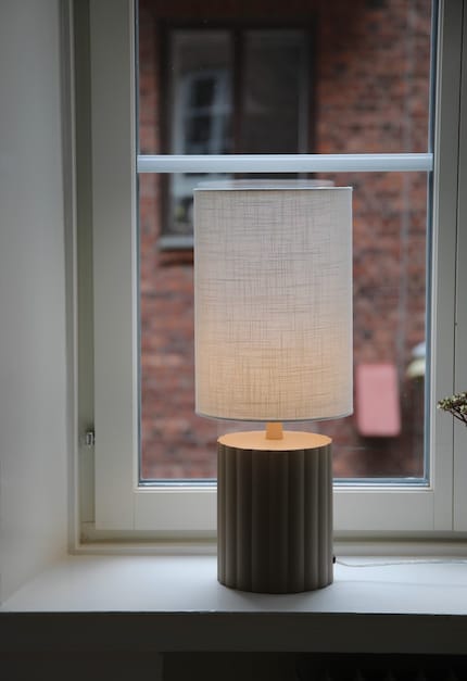 A fabric shade filters the light and distributes it evenly throughout the room.